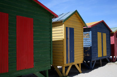 Multi colored houses on beach against sky