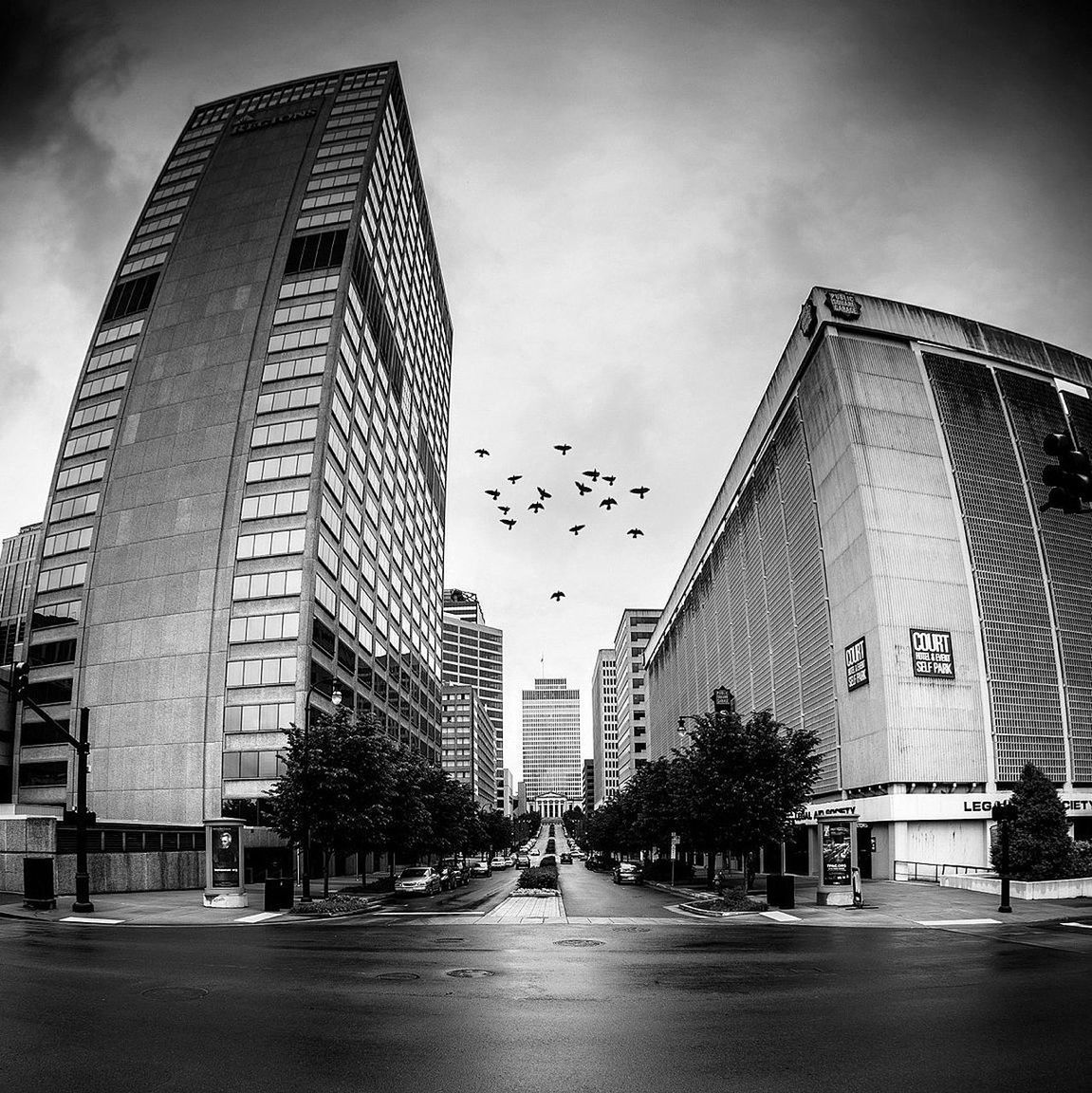 building exterior, architecture, built structure, sky, the way forward, city, street, transportation, road, diminishing perspective, building, road marking, cloud - sky, low angle view, car, street light, day, outdoors, incidental people, vanishing point