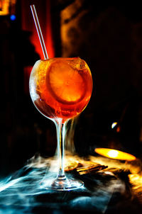 Close-up of wineglass amidst smoke on table