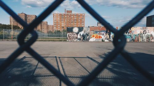 Shadow of chainlink fence against sky