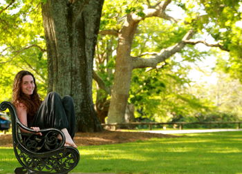 Woman sitting on tree trunk in park