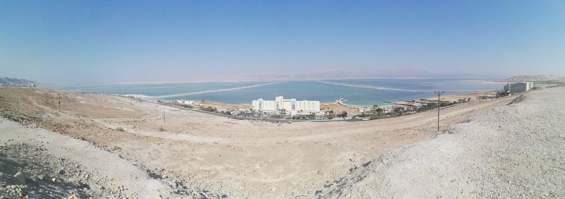 Scenic view of desert by dead sea against sky