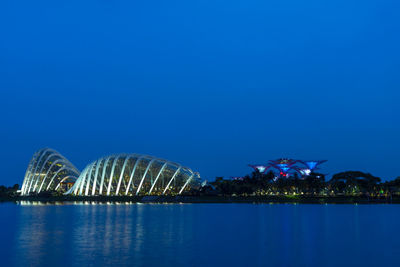 Illuminated modern building against blue sky at night