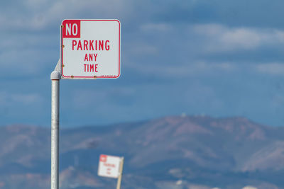 Low angle view of road sign against sky