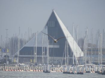 View of sailboat on building by sea against sky