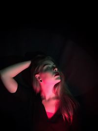 Light on beautiful young woman in darkroom