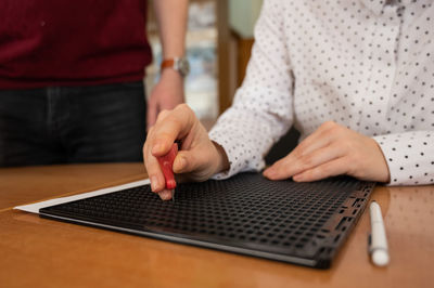 Midsection of man using laptop on table