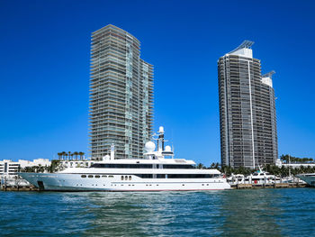 Modern building by sea against clear blue sky