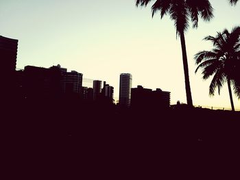 Buildings against clear sky at sunset