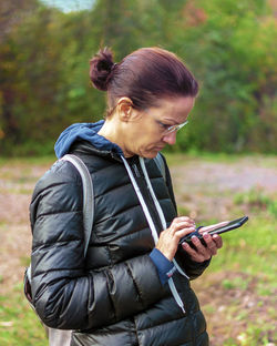 Woman using mobile while standing outdoors