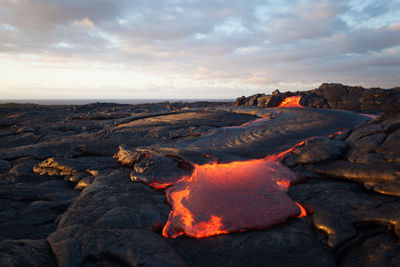 Scenic view of volcano erupting against sky during sunset