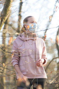 Woman wearing mask standing at park