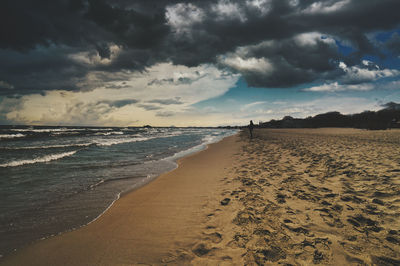 Scenic view of beach against sky during storm