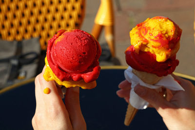 Cropped hand of women holding ice cream cones