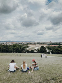 People sitting at park against sky