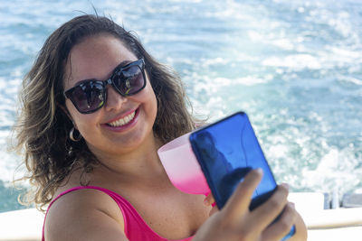 A woman on top of a boat against the sea in the background. 