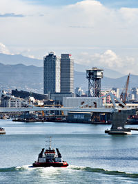 Ships in sea against sky in city