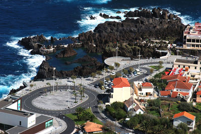 Aerial view of road and buildings by blue sea