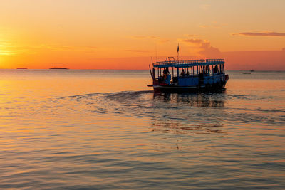 Silhouette view of traditional maldivian boat - dhoni , gliding on water at sunset, maldives 