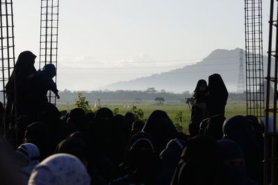 Women wearing burkhas standing on field