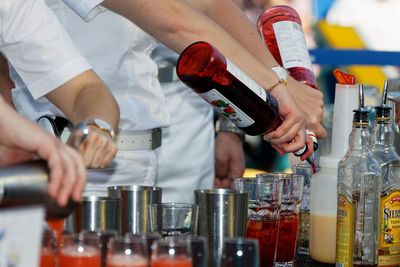 Midsection of man working with wine bottles