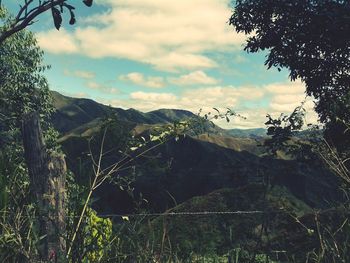 Scenic view of mountains against cloudy sky