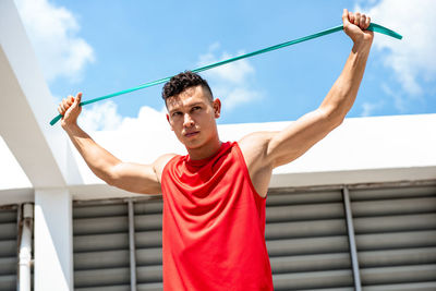 Low angle view of man standing against blue sky