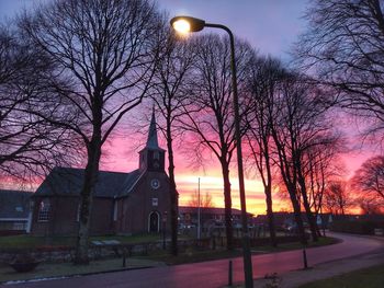 Street amidst buildings against sky at dusk