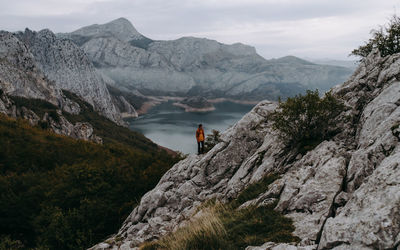 Man on rocks by mountains