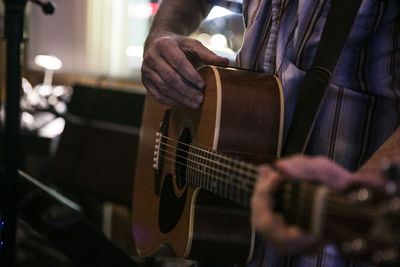 Midsection of man playing guitar