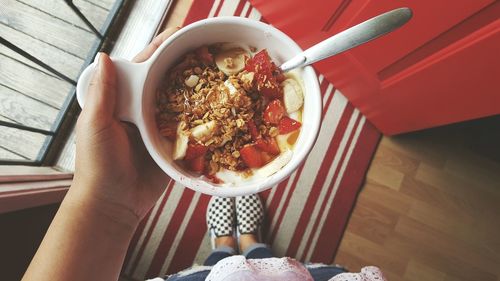 Woman holding bowl of breakfast cereal