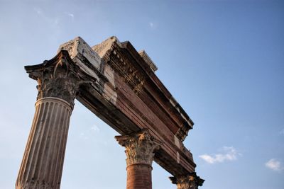 Low angle view of old ruined roman columns against sky