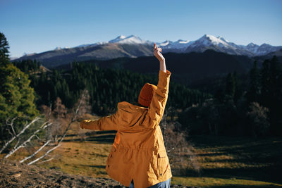 Rear view of woman standing against mountain