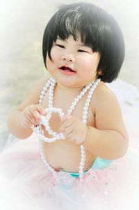 Baby girl wearing pearl necklace