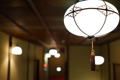 Low angle view of illuminated pendant lights hanging from ceiling