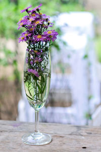 Flower vase on table against glass wall