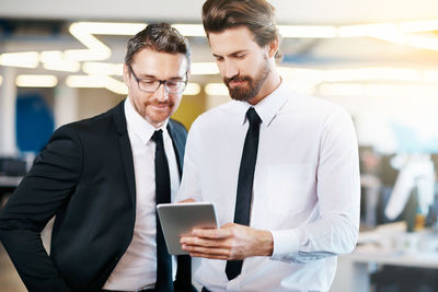 Businessmen looking at digital tablet in office