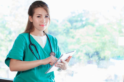 Portrait of young female doctor using digital tablet