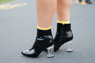 Low section of man standing on road