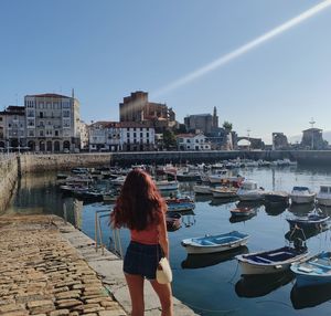 Rear view of woman looking at sea against clear sky