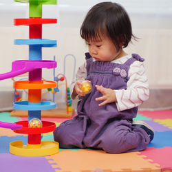 Baby girl playing with toys at home