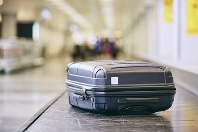 Close-up of black suitcase on conveyor belt at airport