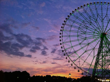 Low angle view of ferris wheel against sky at sunset