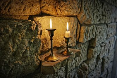 Close-up of illuminated lamp against wall