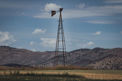 Windmill on field against sky