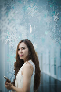 Side view portrait of woman by snowflake decorations