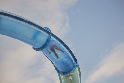 Close-up of glass bottle against blue sky