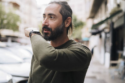 Mature man with beard talking into smart watch