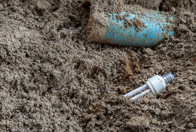 Close-up of bottle with water drops on shore