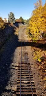 Railroad track amidst trees against clear sky